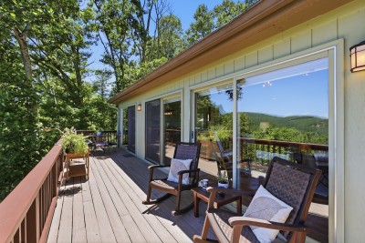 Your mountain-view deck awaits — expansive lounge seating, towering forest surroundings, and sweeping Beech Mountain vistas create an outdoor living experience that is impossible to leave behind.