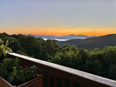 Sunset mountain views from the deck above a lush, peaceful forest