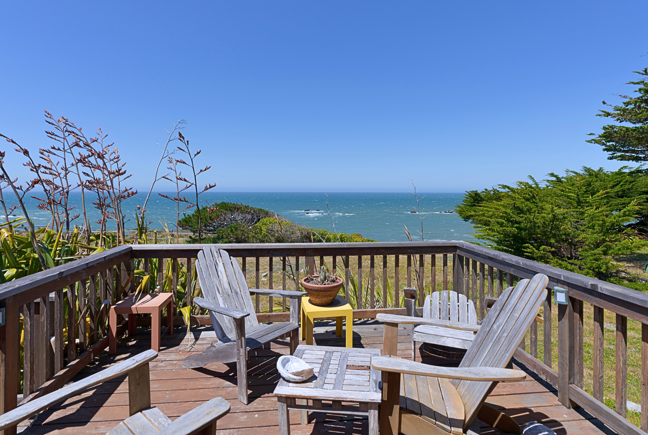 Ocean-view deck with Adirondack chairs and peaceful coastal scenery