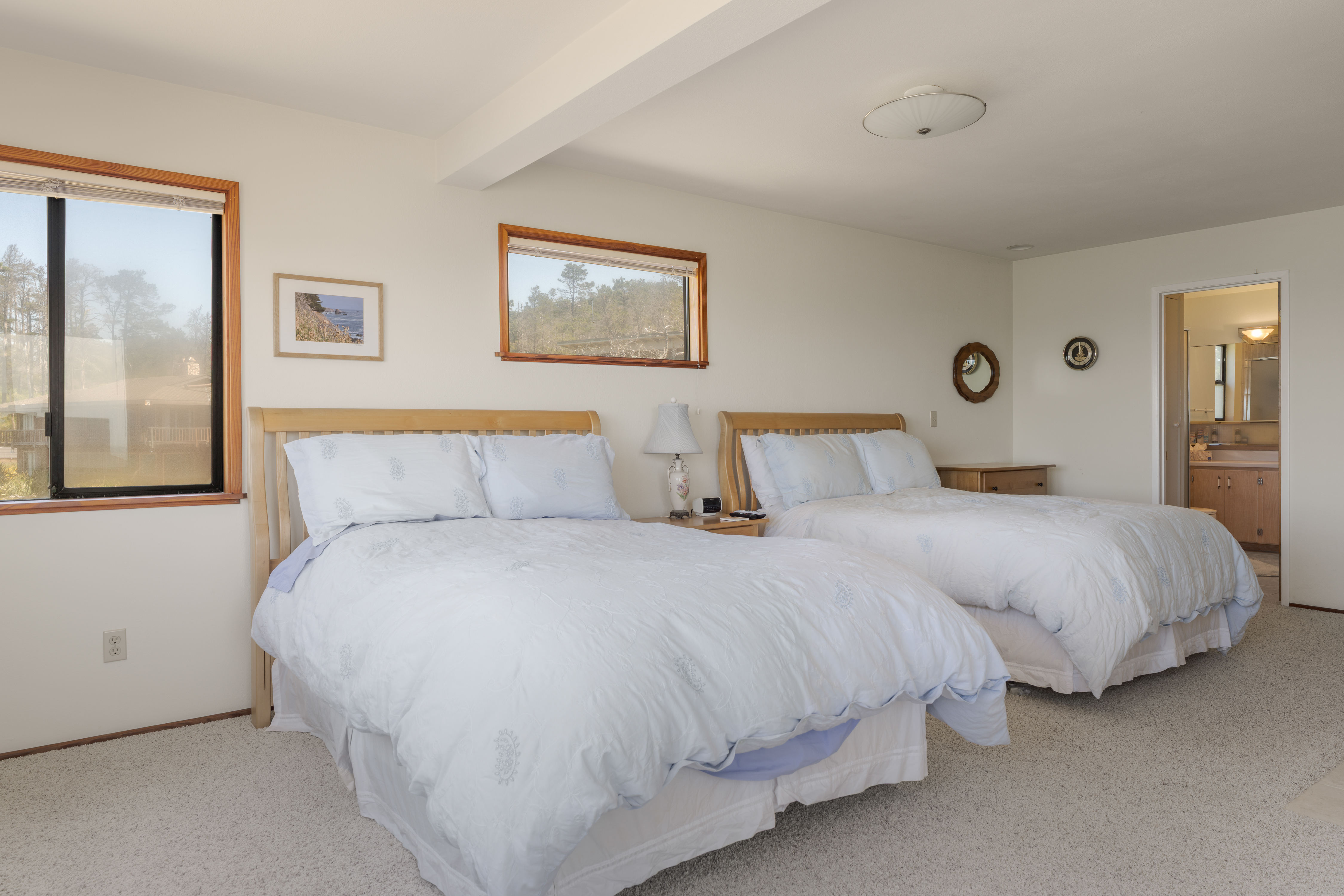 Spacious double-queen bedroom with natural light and en suite access