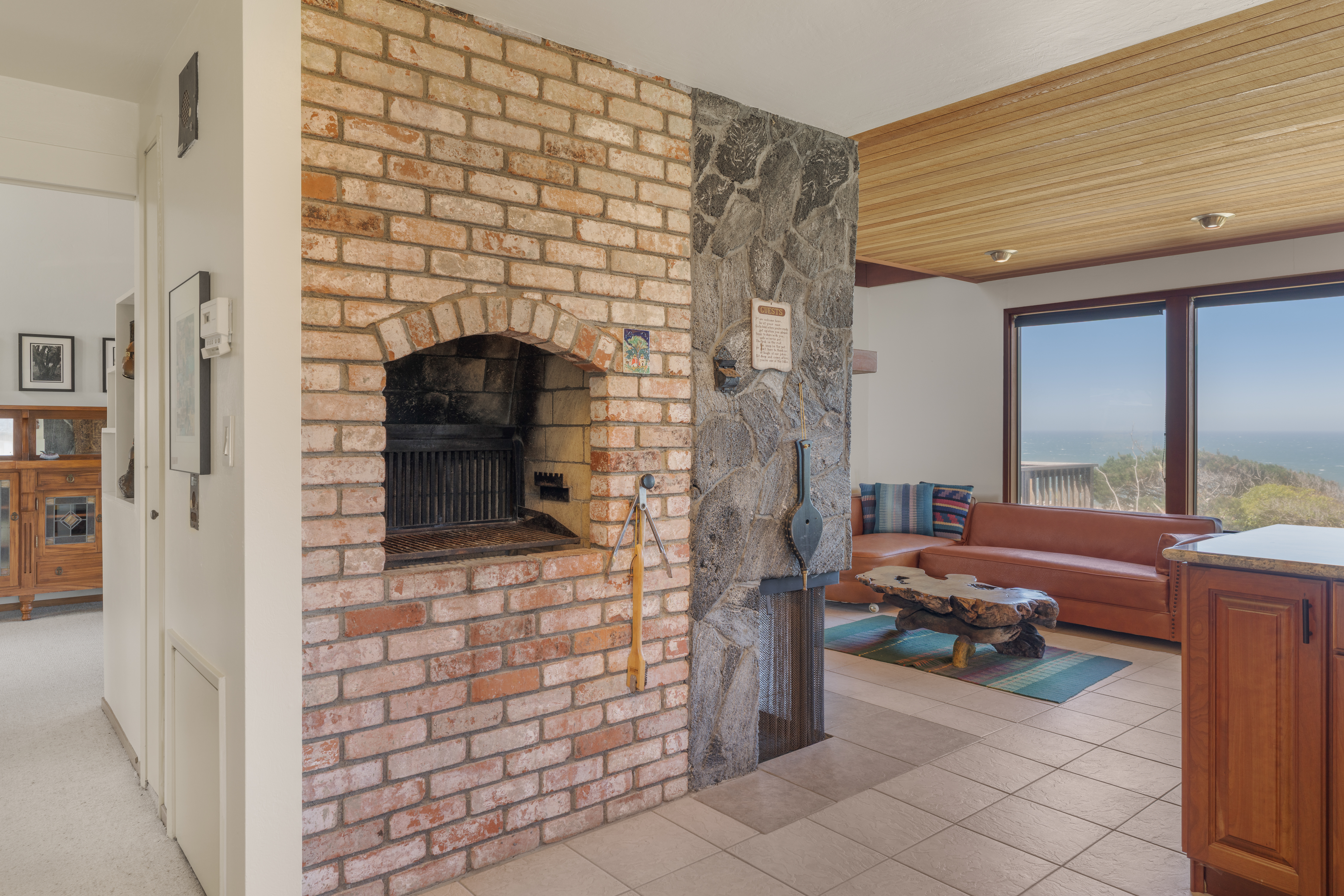 Cozy ocean-view lounge with rustic fireplace and warm wood accents