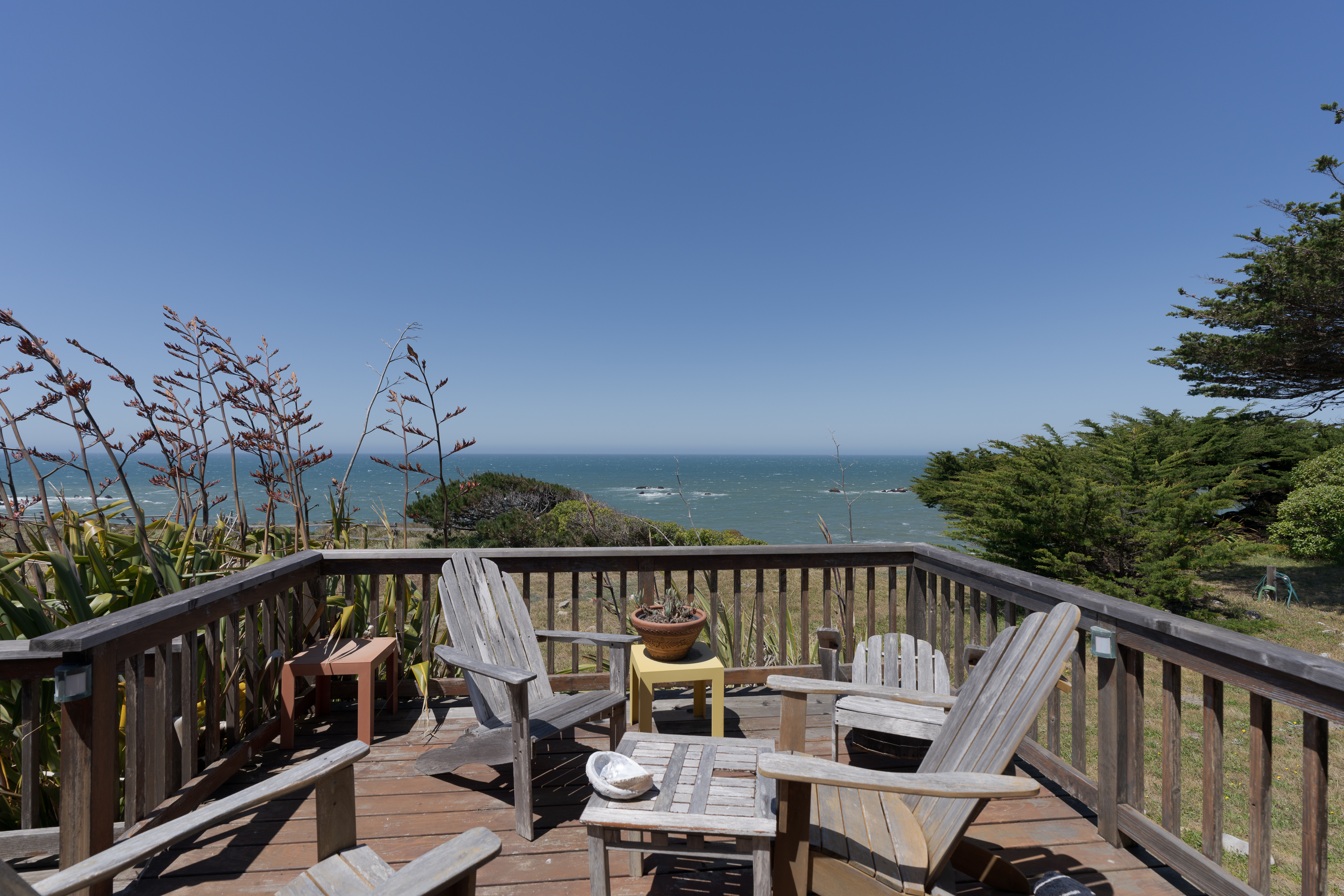 Ocean-view deck with Adirondack chairs for peaceful coastal lounging