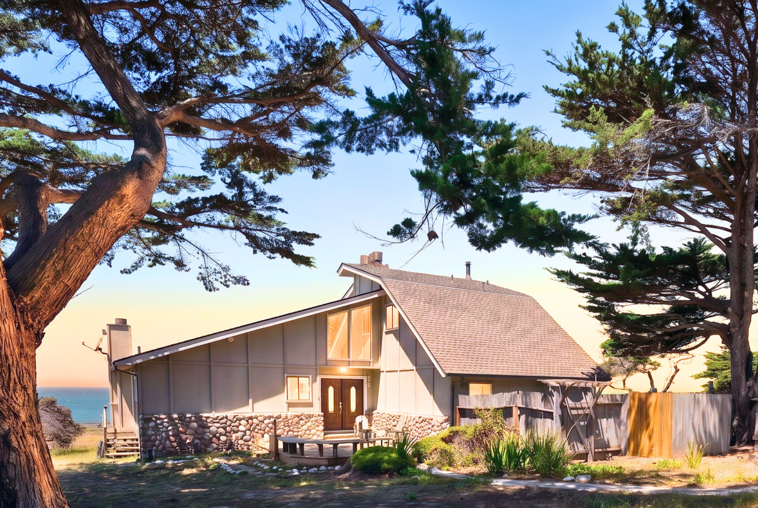 Charming coastal A-frame nestled among trees with ocean views