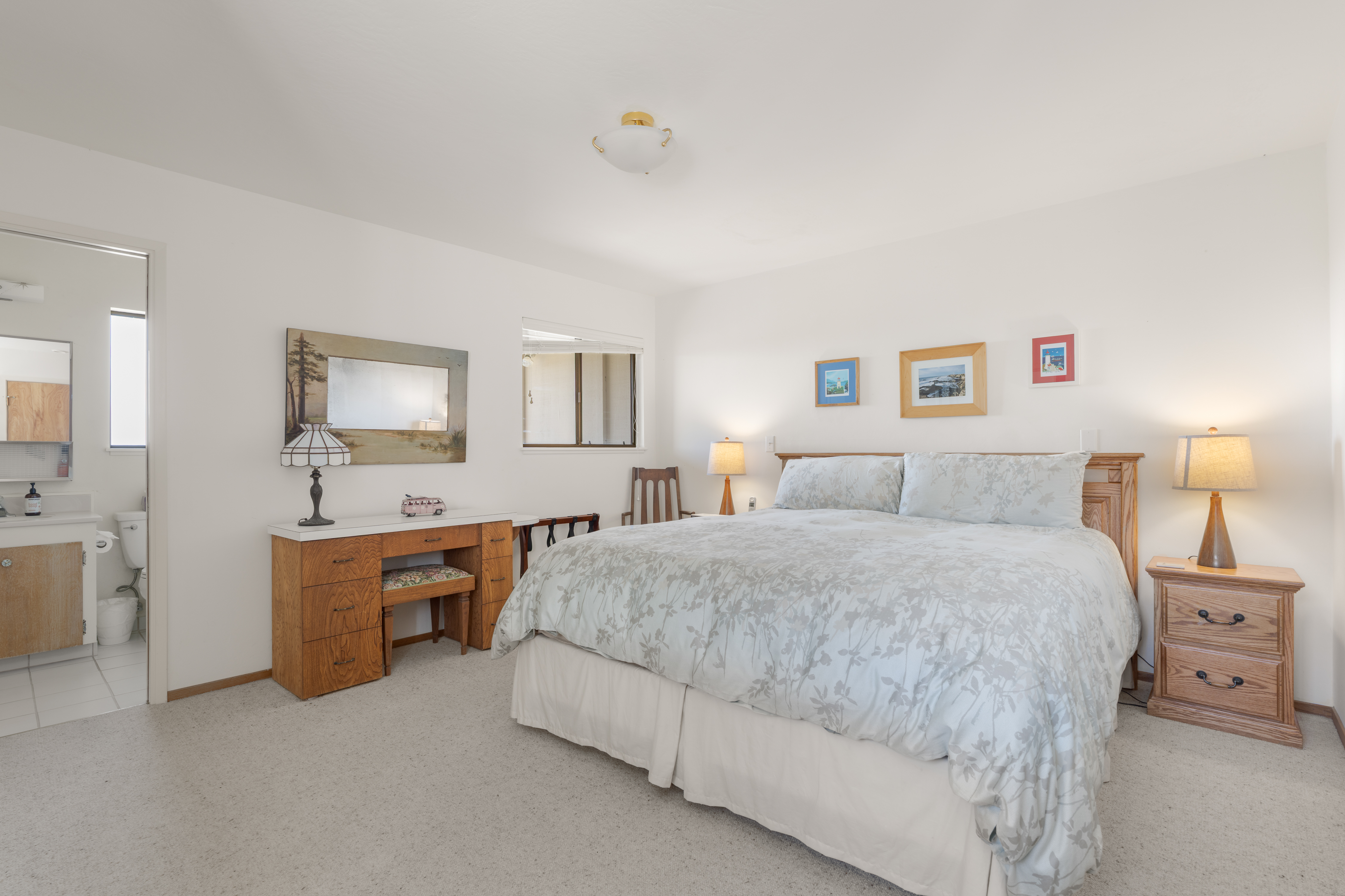 Spacious king bedroom with en-suite bath and cozy bedside lighting