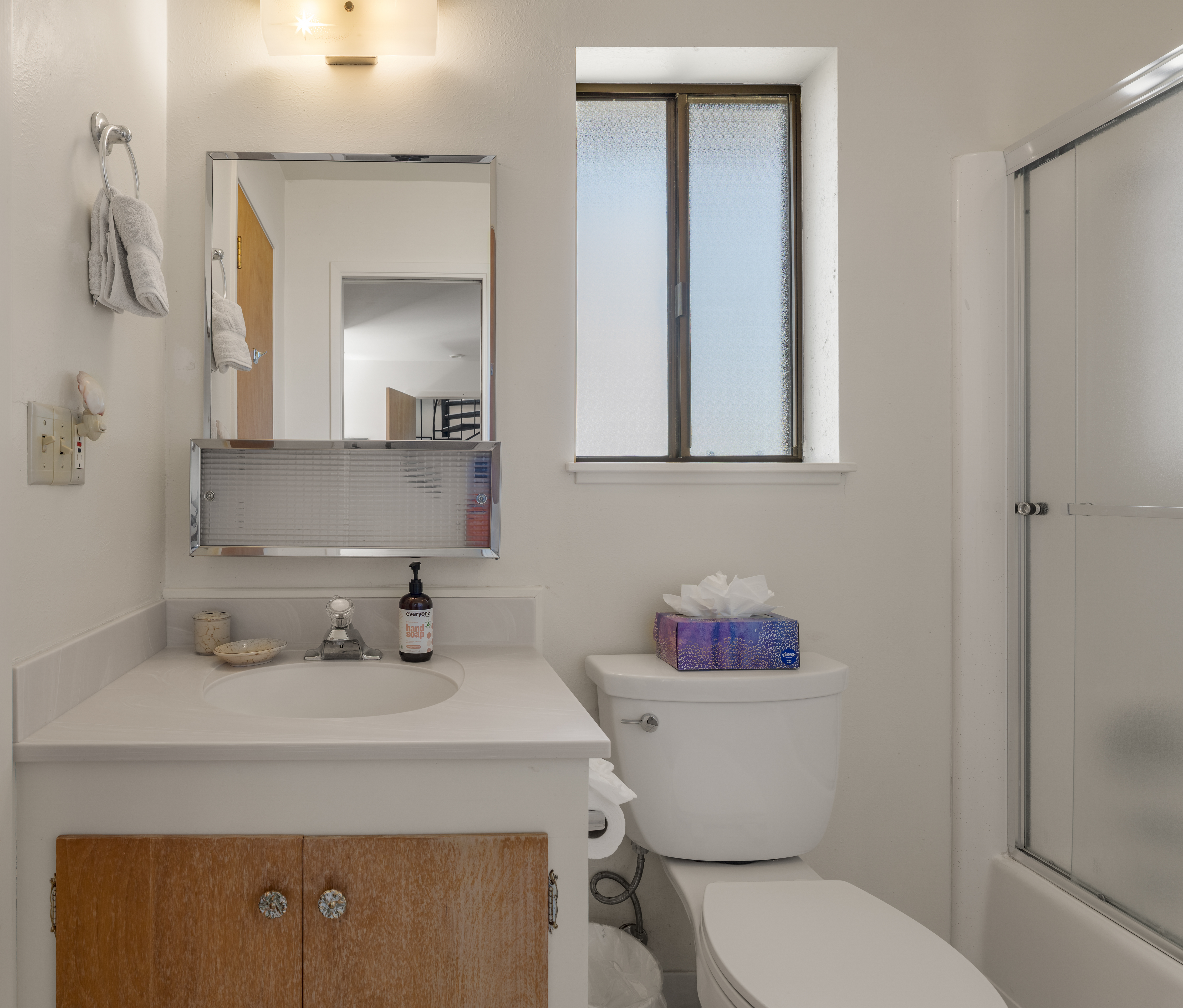 Bright, clean bathroom with natural light and tub-shower combo