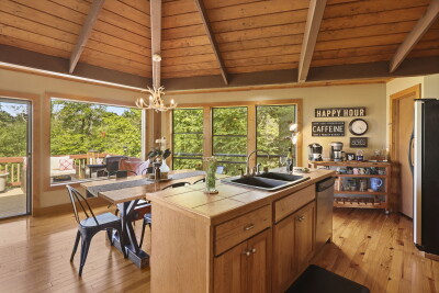 The bright rustic kitchen at Beech Mountain Place impresses at every turn — island seating, gorgeous forest views, and direct deck access create a warm and inviting space perfect for cooking and gathering together.
