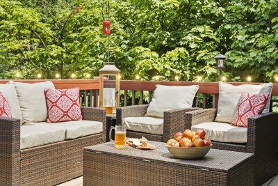 The private wooded deck glows with charm — comfortable lounge seating and warm string lights create an inviting evening retreat surrounded by peaceful forest views at Beech Mountain Place.