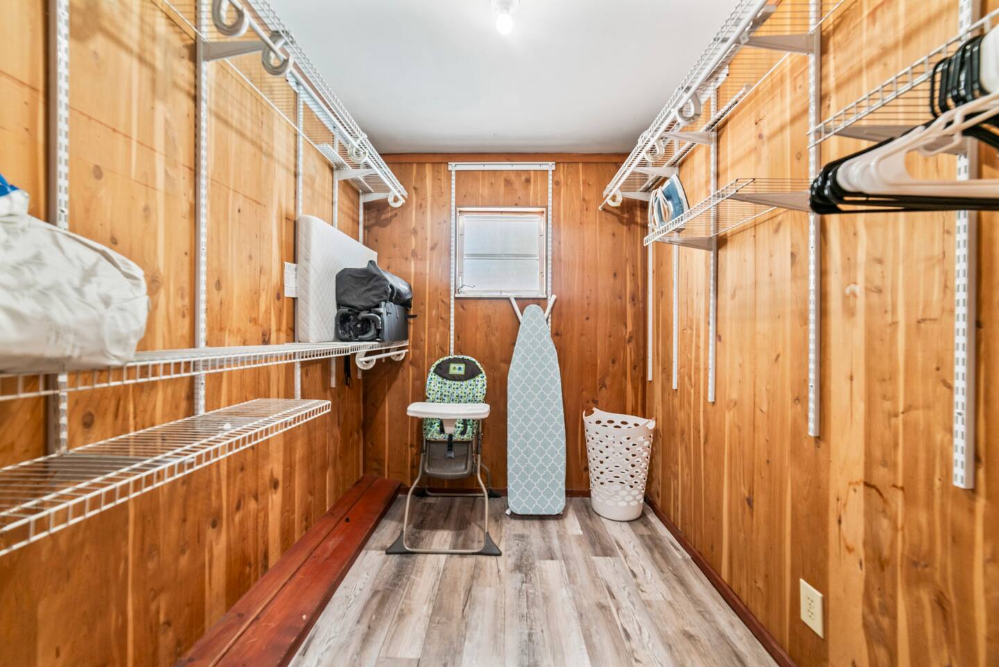 Walk-in closet with plenty of storage space for your stay. You'll also find a travel crib, high chair, iron, ironing board, and a guest information folder with helpful house details and local recommendations.
