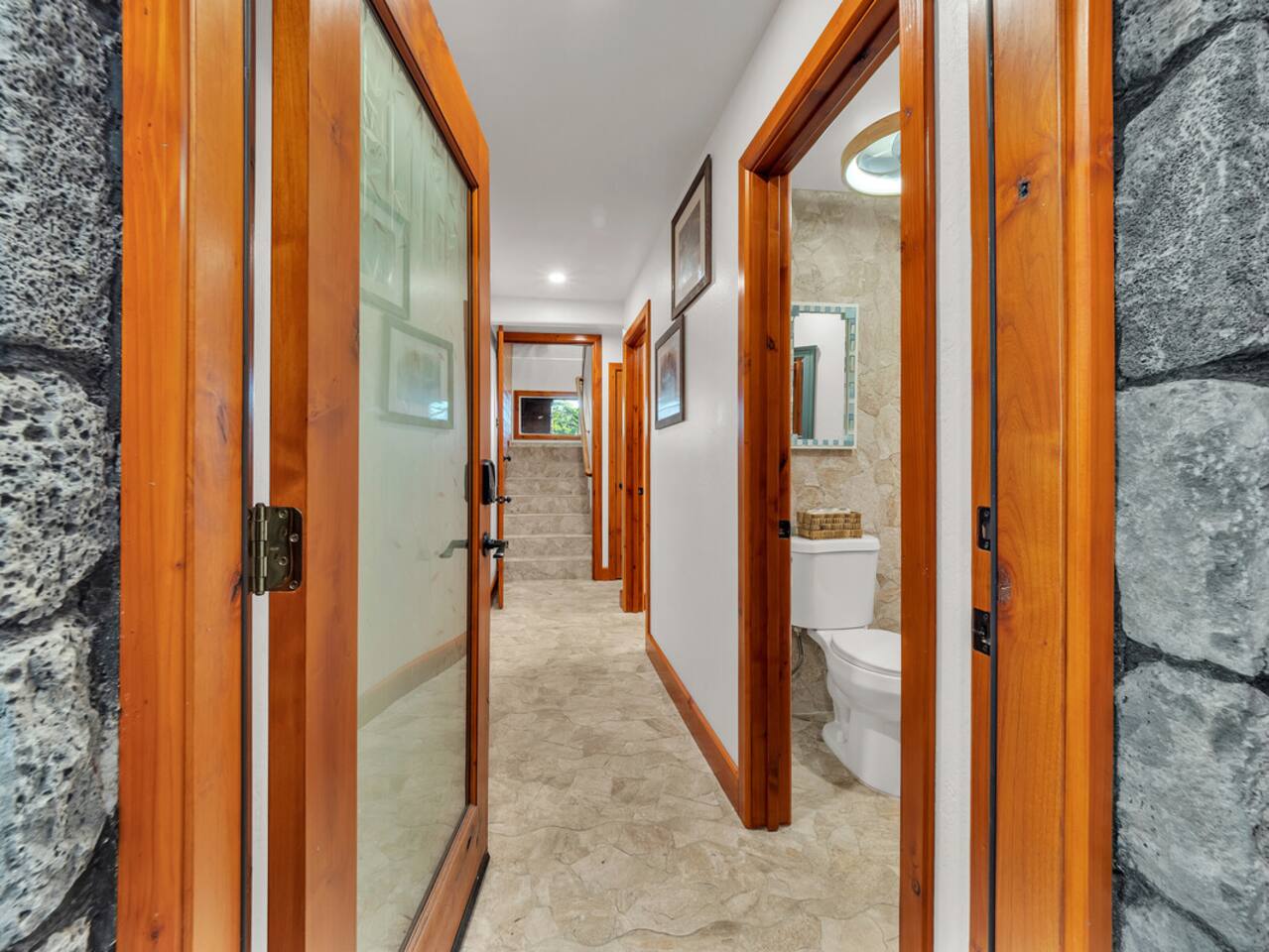 The downstairs hallway leads you past 2 more bedrooms, and a full and half bath, eventually leading you back outside by the outdoor shower.