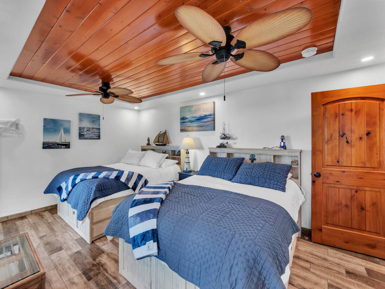 The nautical-themed guest room features two double beds and stunning views of both the ocean and the stream.