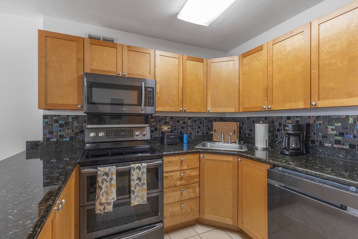 Modern kitchen featuring stainless steel appliances, granite countertops, and ample cabinet space-perfect for cooking and enjoying meals during your stay.