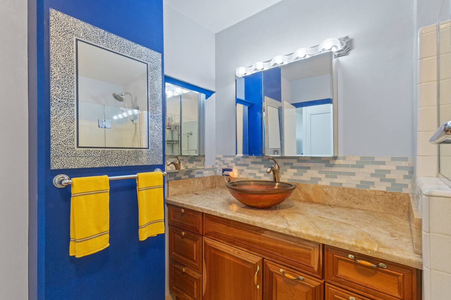 Bright bathroom featuring warm lighting, a modern vessel sink, and a spacious vanity-offering a fresh and comfortable start to your day.