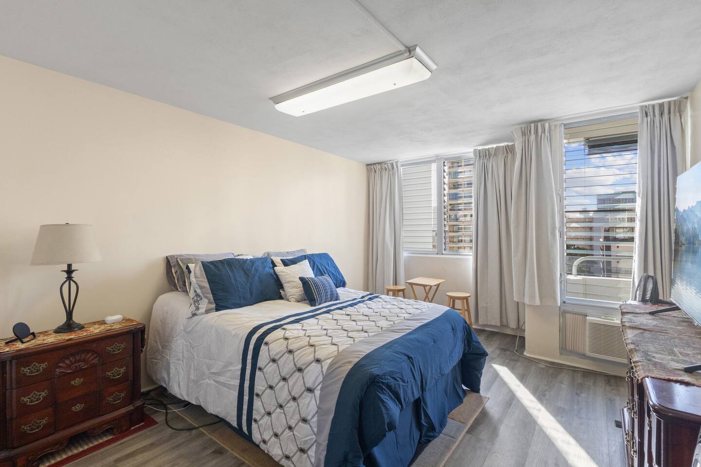 Bright and inviting bedroom with a plush queen bed and plenty of natural light-offering a peaceful retreat in the heart of Waikiki.