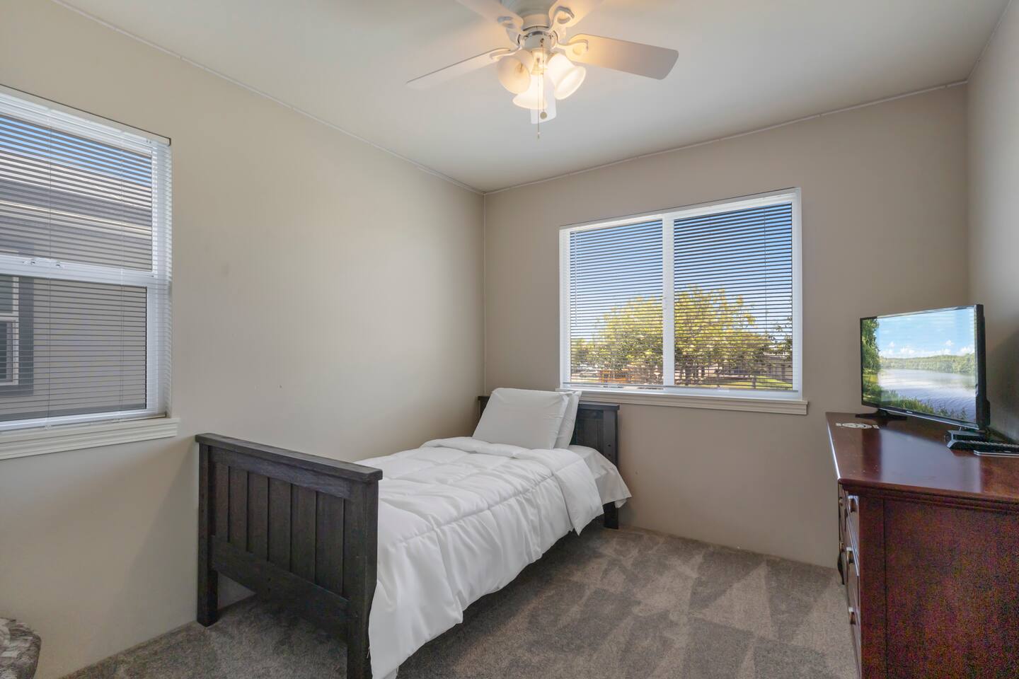 Second twin bedroom featuring a comfortable bed and a TV monitor.