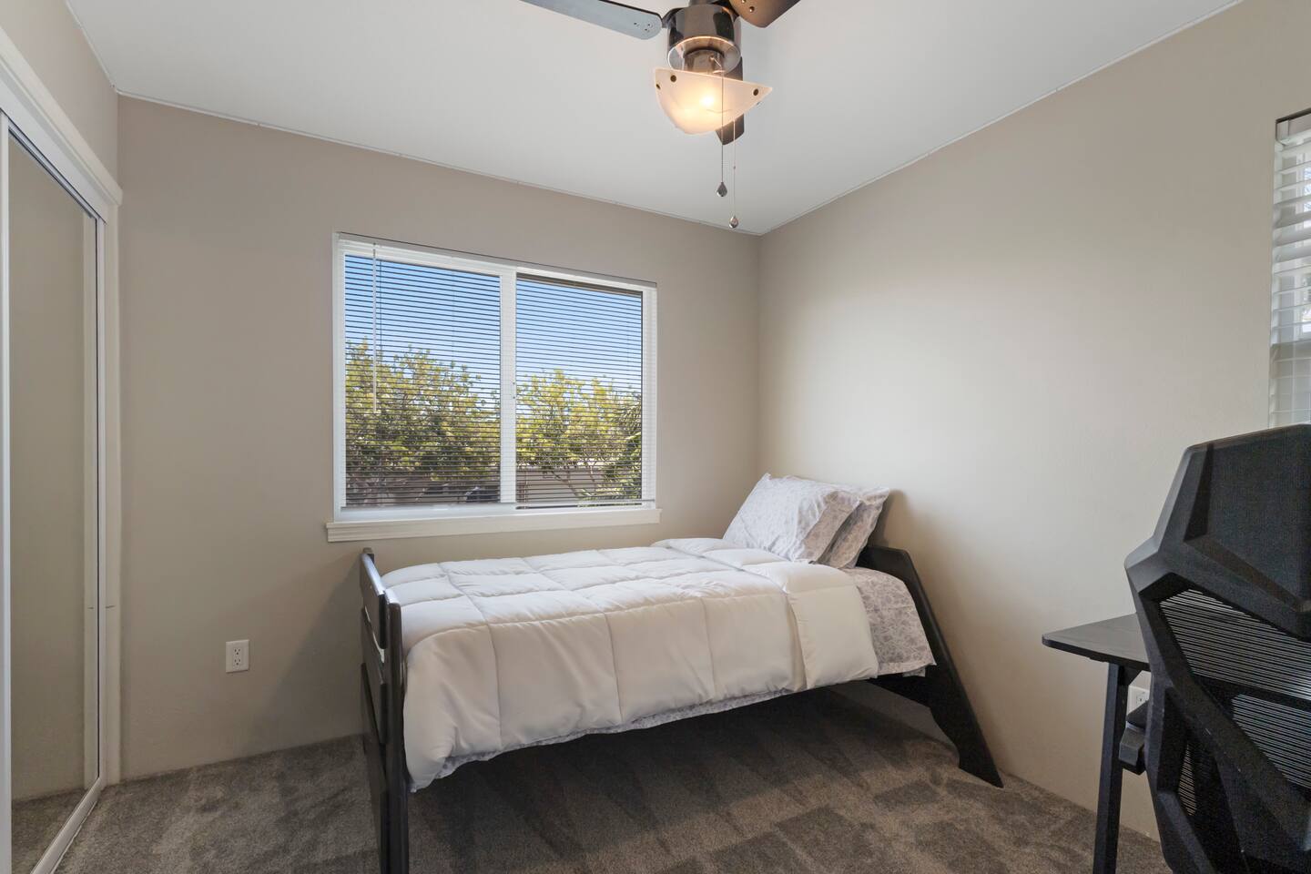 Cozy twin bedroom featuring a comfortable bed and a functional desk-perfect for studying, remote work, or unwinding.
