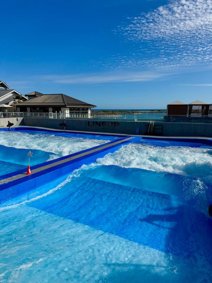 An exciting outdoor wave pool with multiple lanes producing artificial waves, perfect for water fun and surfing practice.