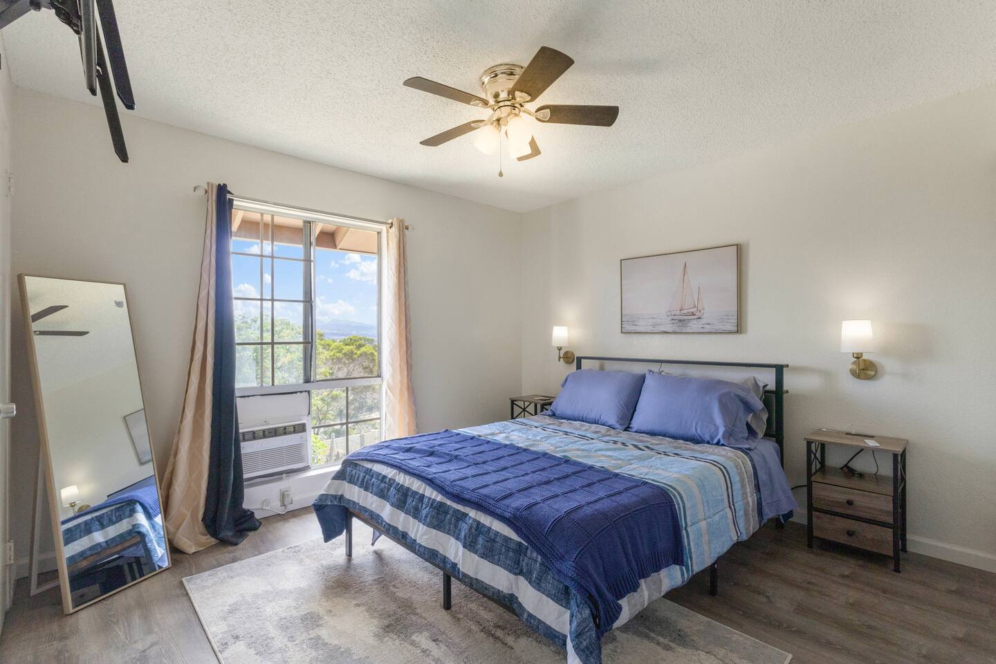 With plush bedding, warm wood floors, and a window that frames the greenery outside, this space is made for deep rest and easy mornings.