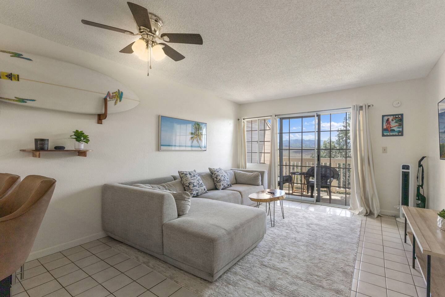With soft seating, surf-inspired decor, and a breeze from the balcony, this living room invites you to kick back and stay awhile.