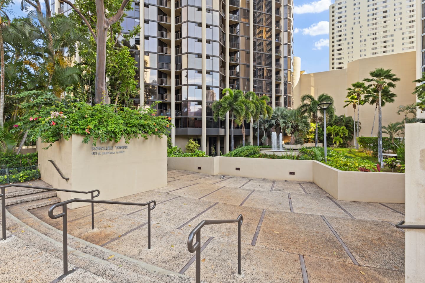 Framed by swaying palms and manicured paths, the entrance to Honolulu Tower sets the tone for upscale living in the heart of Honolulu.
