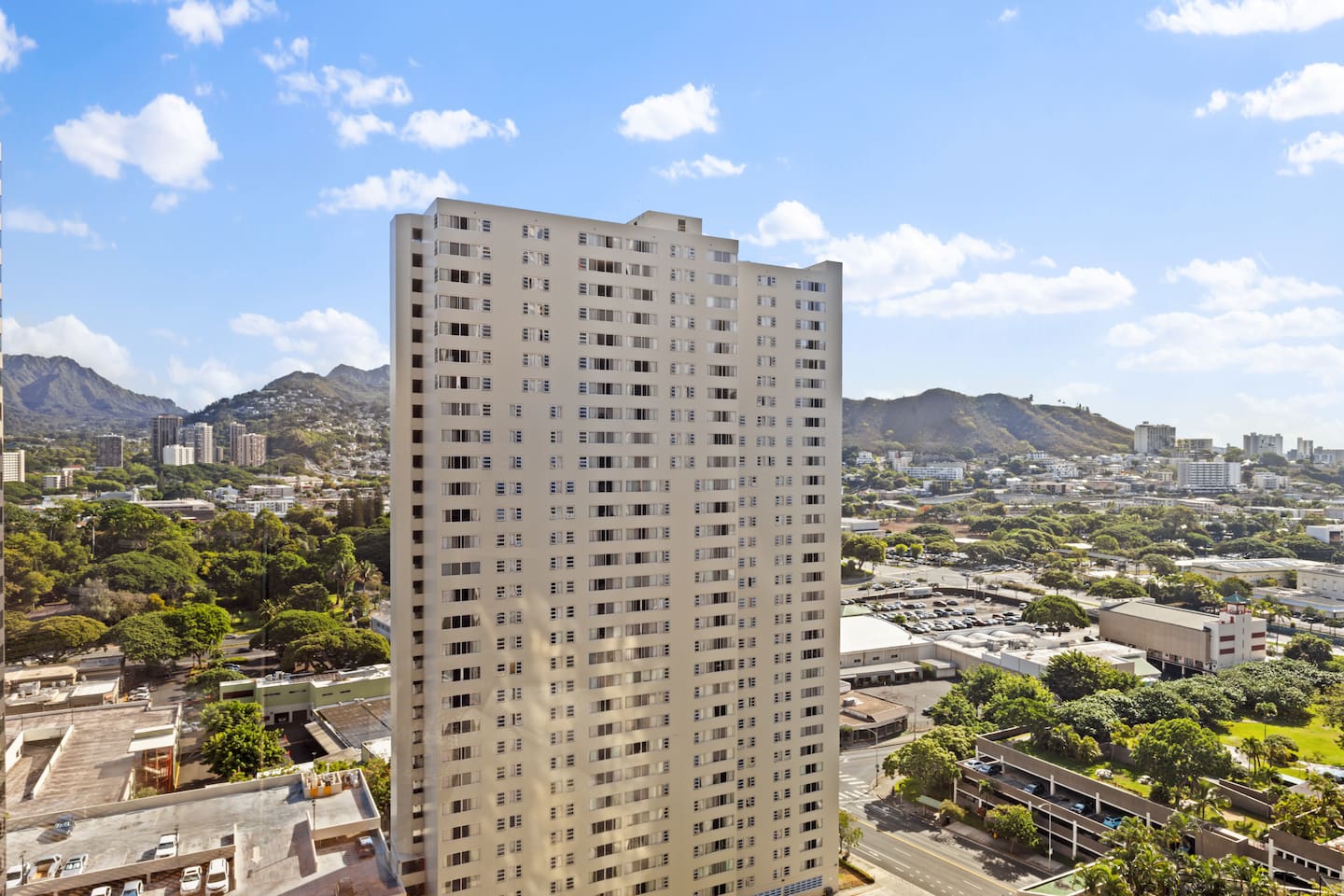Rising above the treetops and framed by lush mountains, this high-rise offers a striking blend of city energy and island serenity.