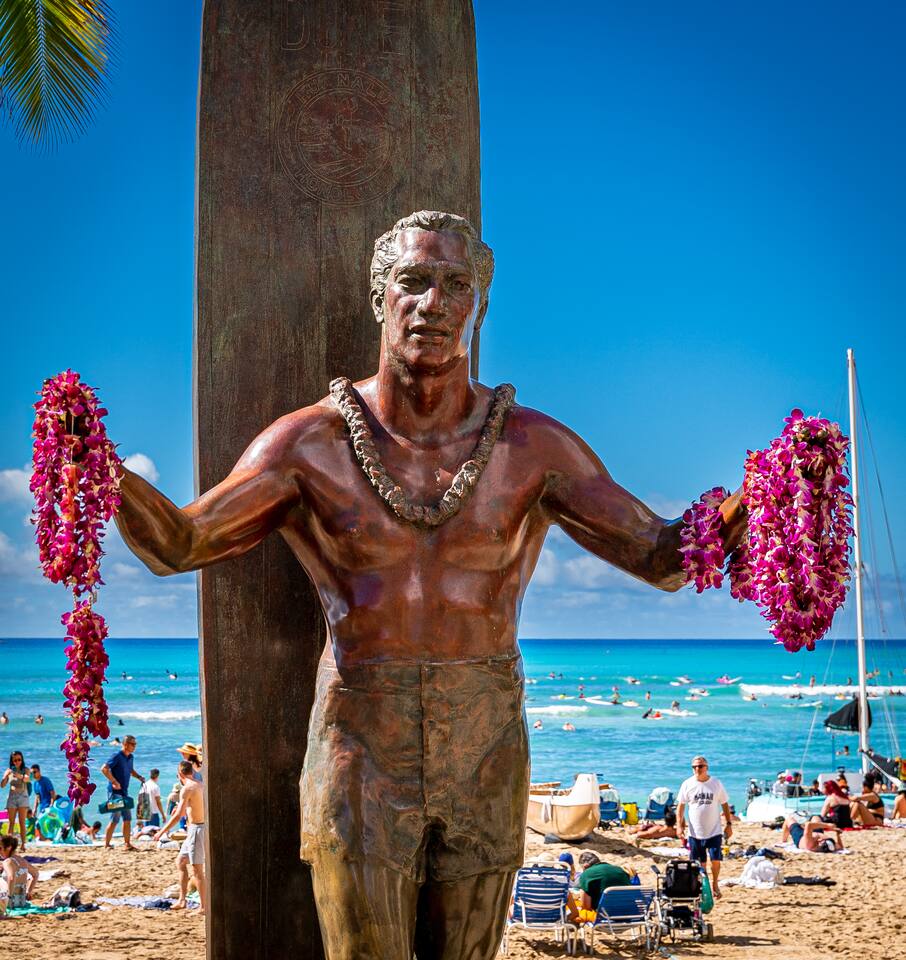 Greeted by leis and ocean breeze, Duke Kahanamoku stands tall an icon of aloha and wave-riding spirit.