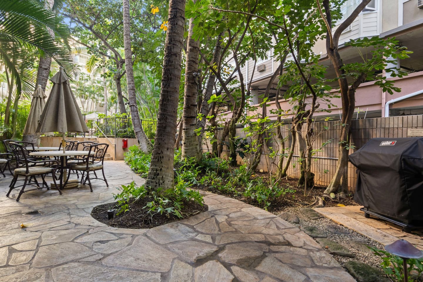 Grill ready, shade set, and greenery all around. This patio was made for laid-back gatherings. Island living, alfresco style.