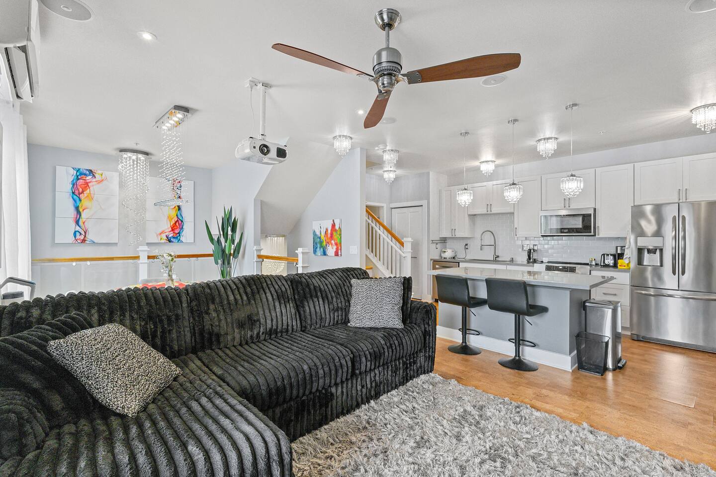 Open-concept layout with modern kitchen, plush sectional, and natural light throughout.