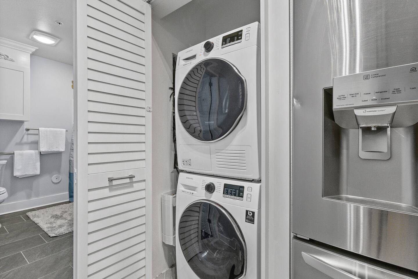 Stacked washer and dryer with digital controls, plus full kitchen appliances all within arm’s reach.