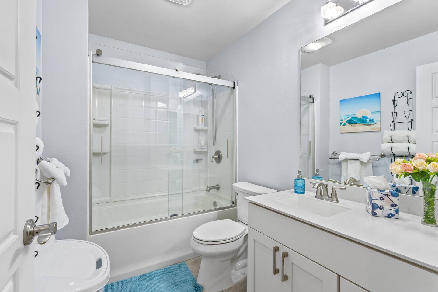 Unwind in this spa-inspired bathroom with soft florals, marble finishes, and a clean coastal vibe.