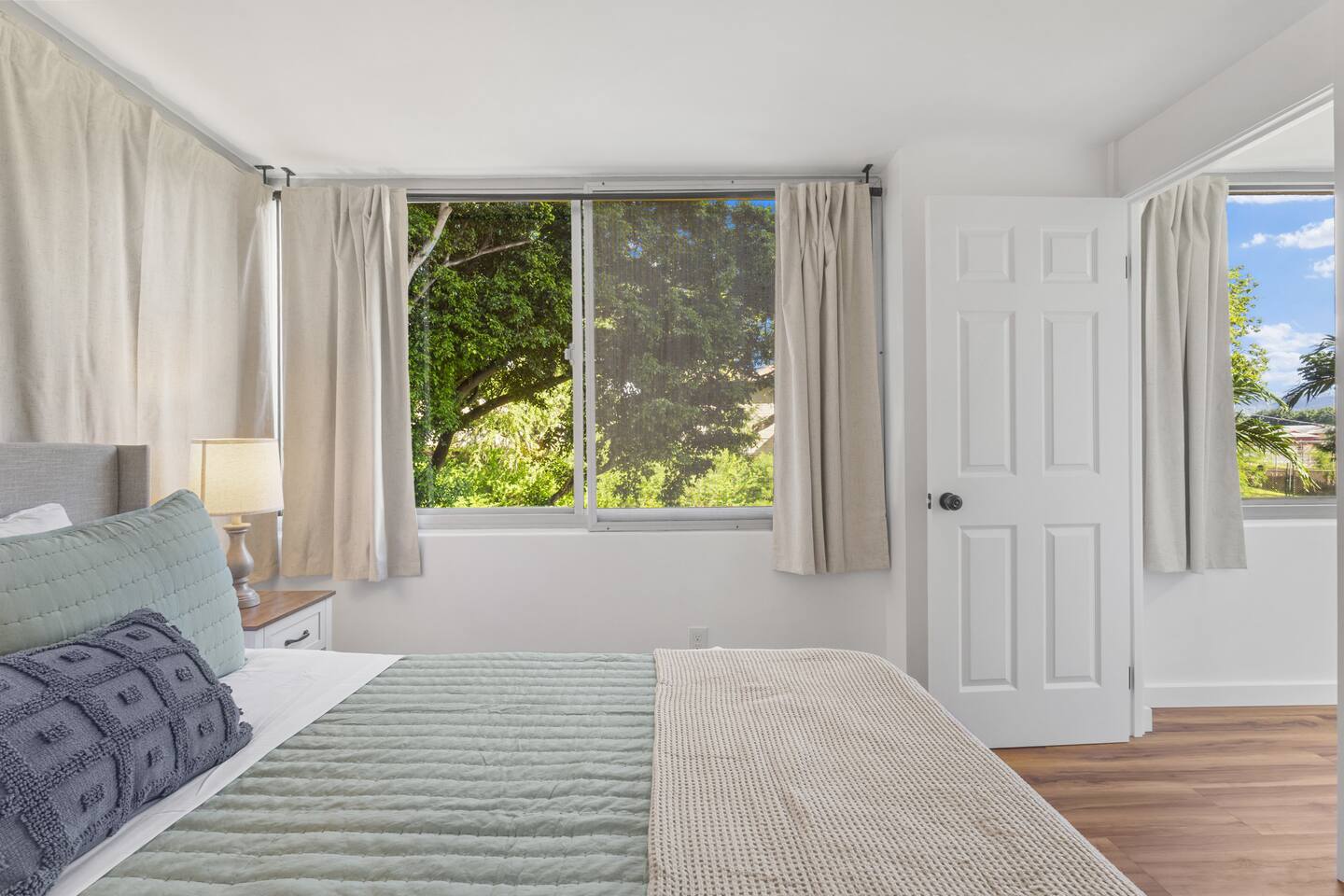 Simple, fresh, and full of light, this bedroom opens to blue skies and leafy calm.