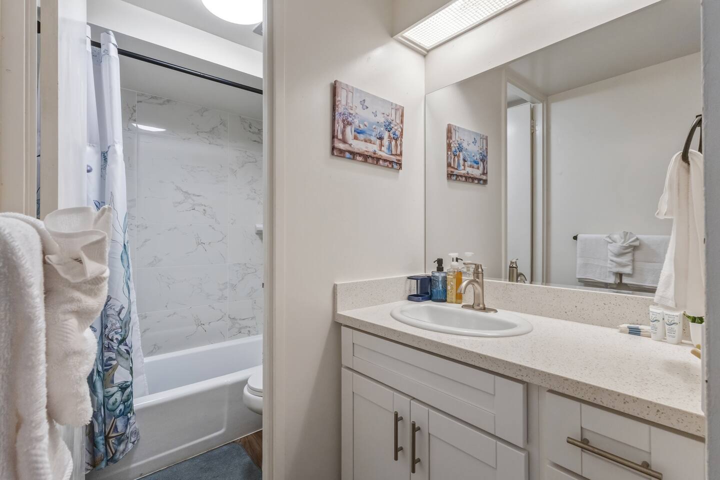 Simple comfort with a polished touch. Bright mirror, tidy counter, and a shower that feels like home.