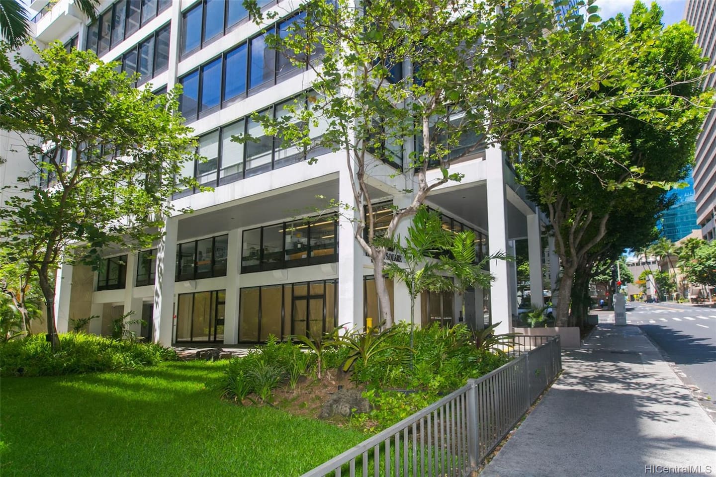 Your peaceful city backdrop, where glass windows meet green landscaping and sunny sidewalks.