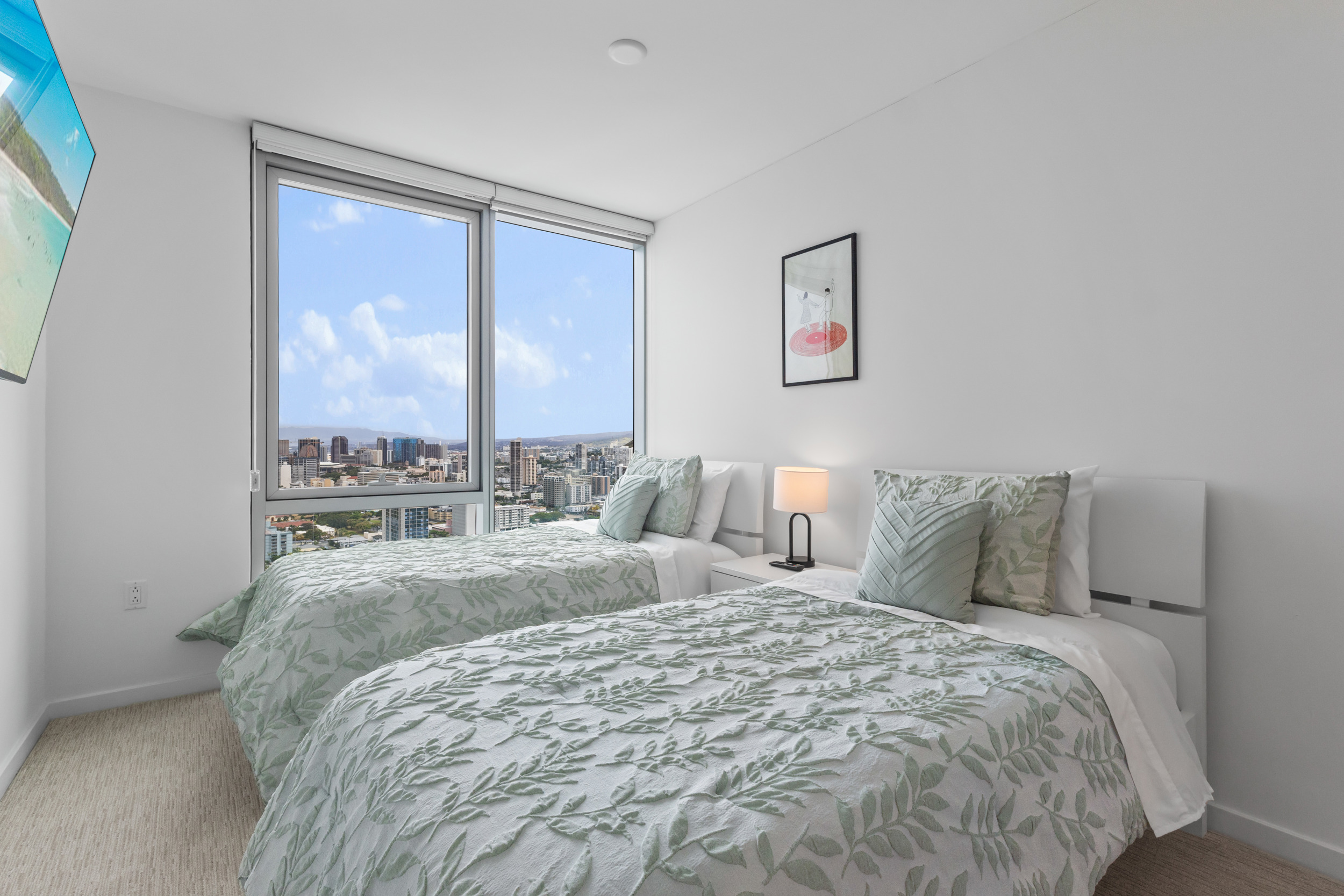 Bright twin bedroom with floor-to-ceiling windows and skyline views
