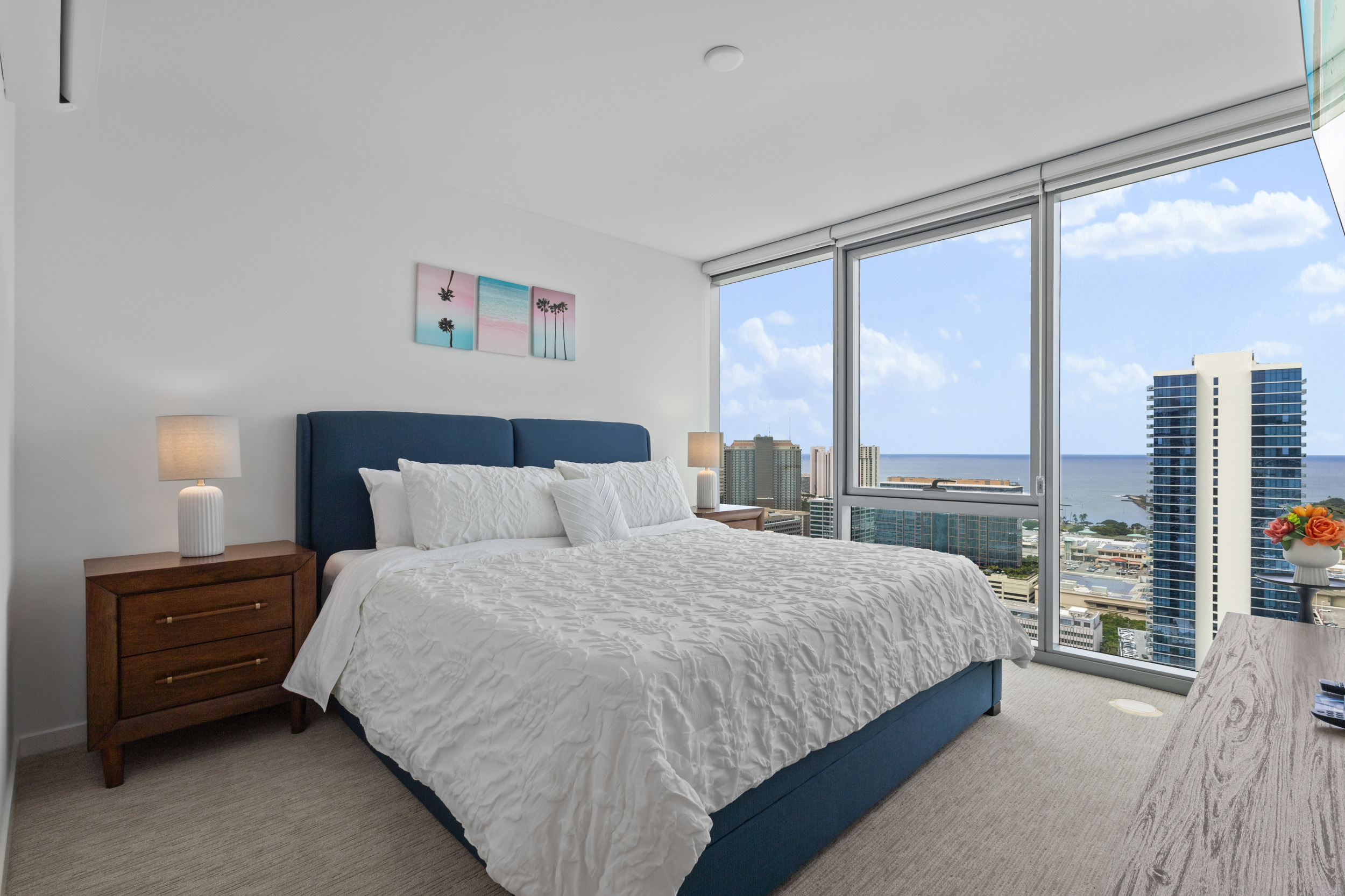 Bright high-rise bedroom with floor-to-ceiling windows and ocean views