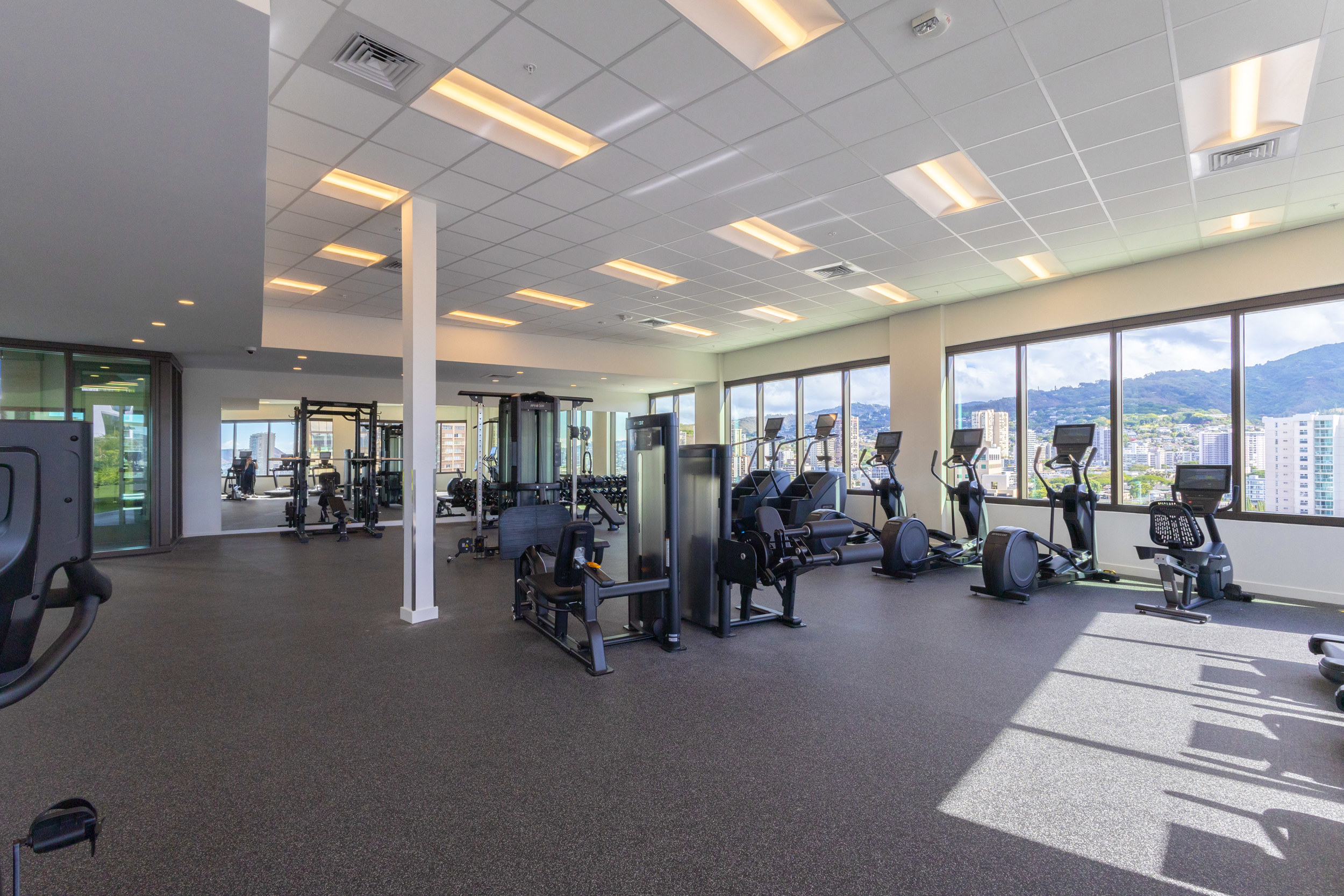Bright fitness center with cardio, weights, and stunning city views