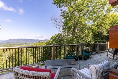 The spacious deck at Rested Traveler is an outdoor living dream — generous seating, a breathtaking mountain view, and a serene forest backdrop that makes every moment spent outside completely unforgettable.