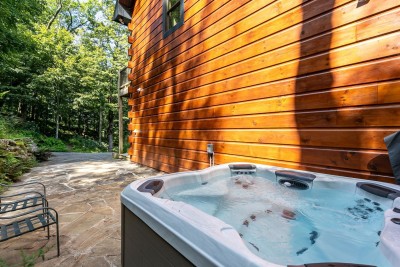 Unwind in the private 8-person Bullfrog Spas hot tub nestled on a serene wooded patio beside the cabin — the perfect spot to soak under the stars and let the peaceful mountain surroundings melt every care away.