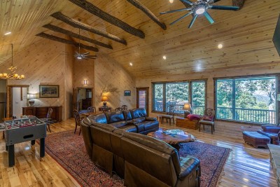The vaulted wood-beam Great Room at Rested Traveler is a masterpiece of mountain design — dramatic exposed beams, lush forest views, and generous seating create a space that is as breathtaking as it is inviting.