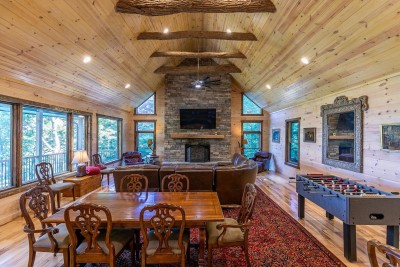 The second Great Room is a showstopper — vaulted ceilings, a stunning stone fireplace, large windows with mountain views, and a foosball table that keeps the competitive energy going all night long.