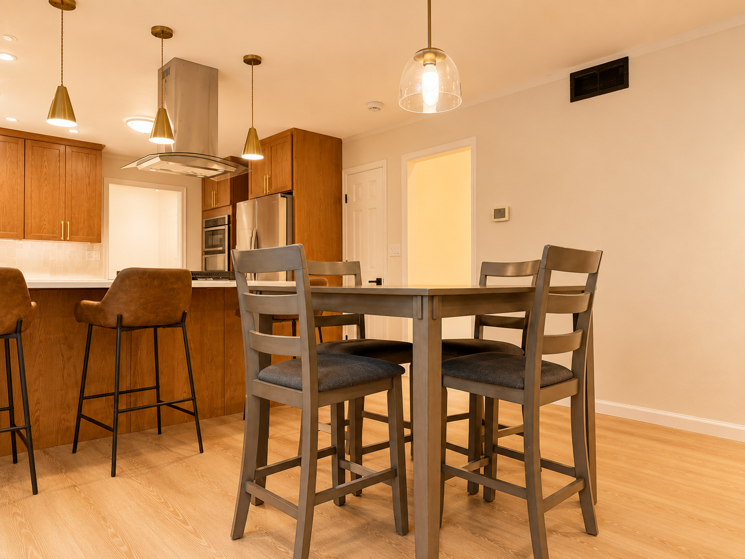 Modern kitchen and high-top dining area with warm lighting