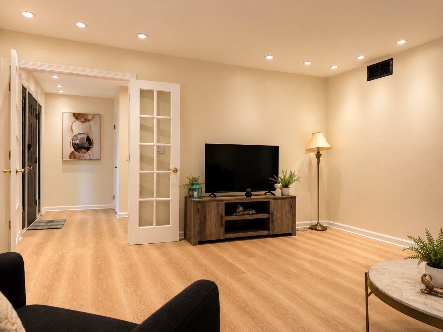 Bright, spacious living area with TV, warm lighting, and open layout