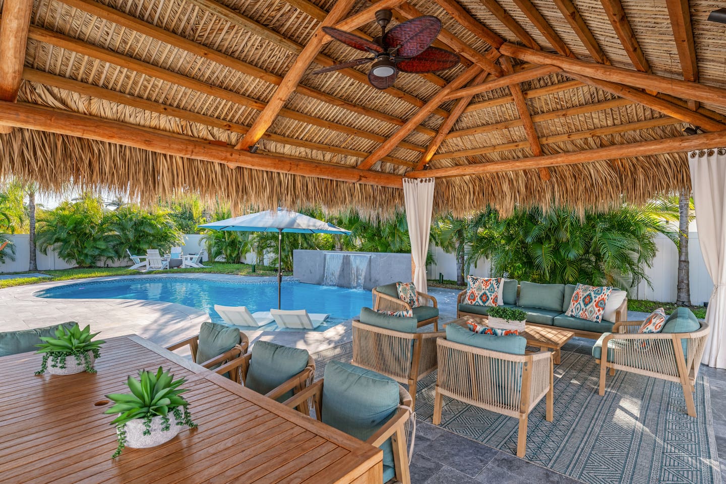 A private cabana with shaded seating, offering a peaceful spot to relax next to the pool.