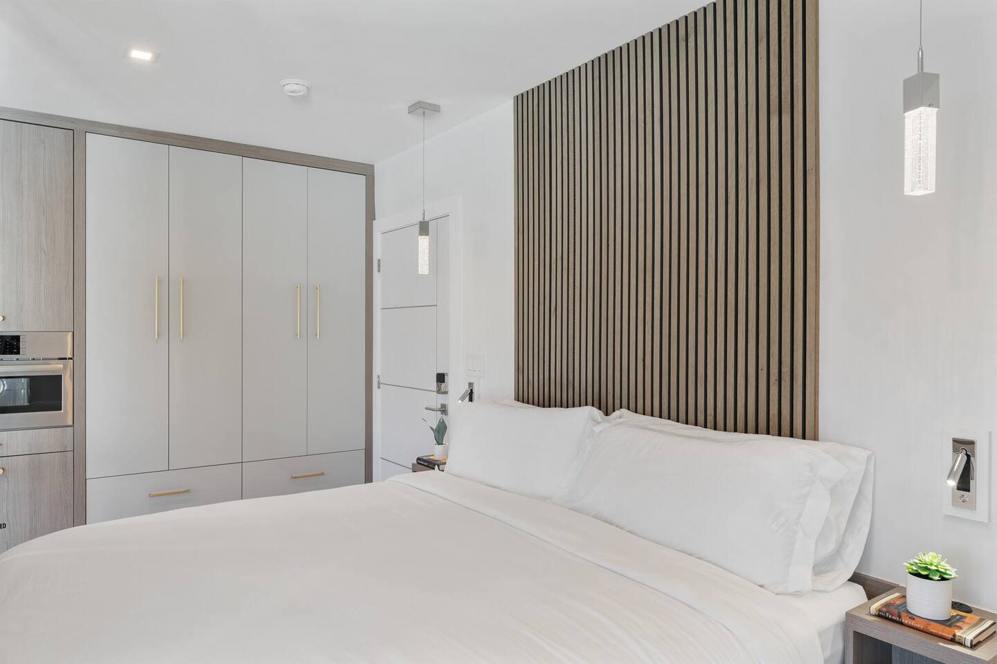 The studio's King bed is nestled just beyond the living space behind a semi-private wall, providing a cozy sleeping area while maintaining the open-concept design.