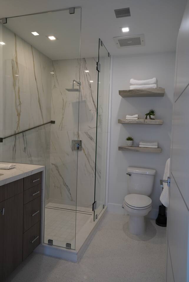 A walk-in shower with a rainfall showerhead