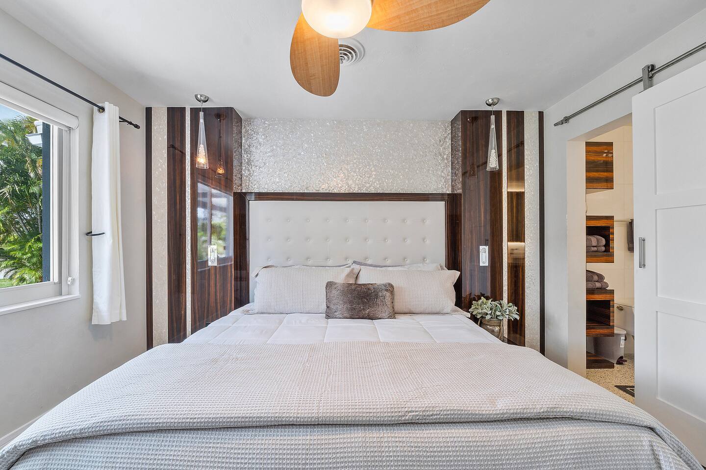 Unwind in the elegant primary suite with a plush king bed, soft linens, bedside lighting, and a peaceful atmosphere designed for a restful night's sleep.