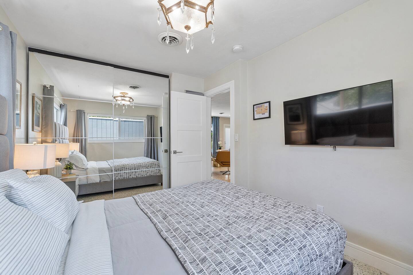 Bedroom 3 features a comfortable full-size bed, Smart TV, modern lighting, and a cabinet with a mirror for added convenience. It's a simple, inviting space that's perfect for relaxing after a day out.