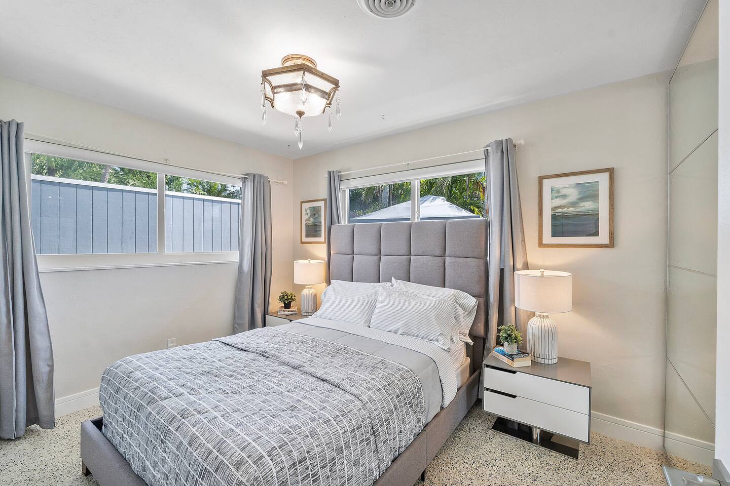 Rest comfortably in Bedroom 3, featuring a plush queen-size bed, elegant chandelier, and expansive windows that fill the room with natural light.