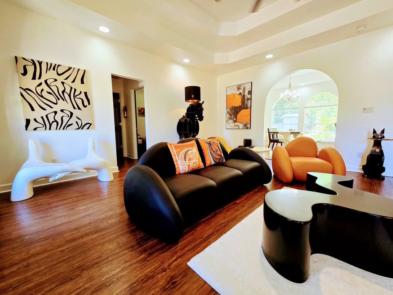 The large living room is well adorned with unique furniture sourced from around the globe. Every item has been carefully chosen for their quality, comfort, and design characteristics.