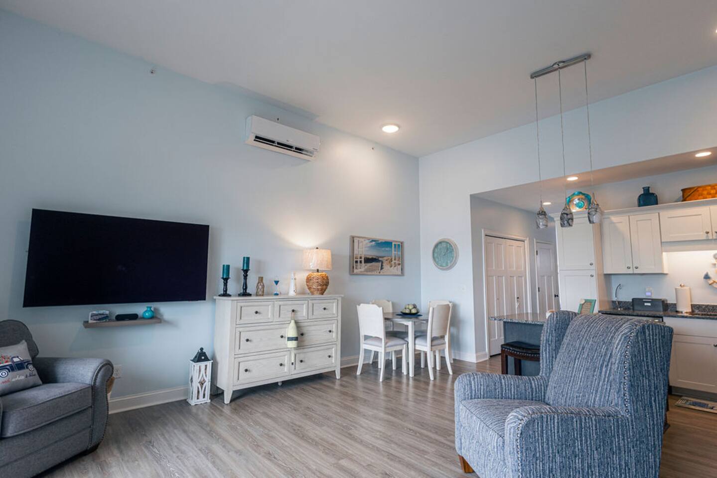 The open concept living room offers access to the dining space with seating for 4,  complete kitchen, large Tv w Roku and the slider leading directly to the 3rd story deck overlooking the bay.