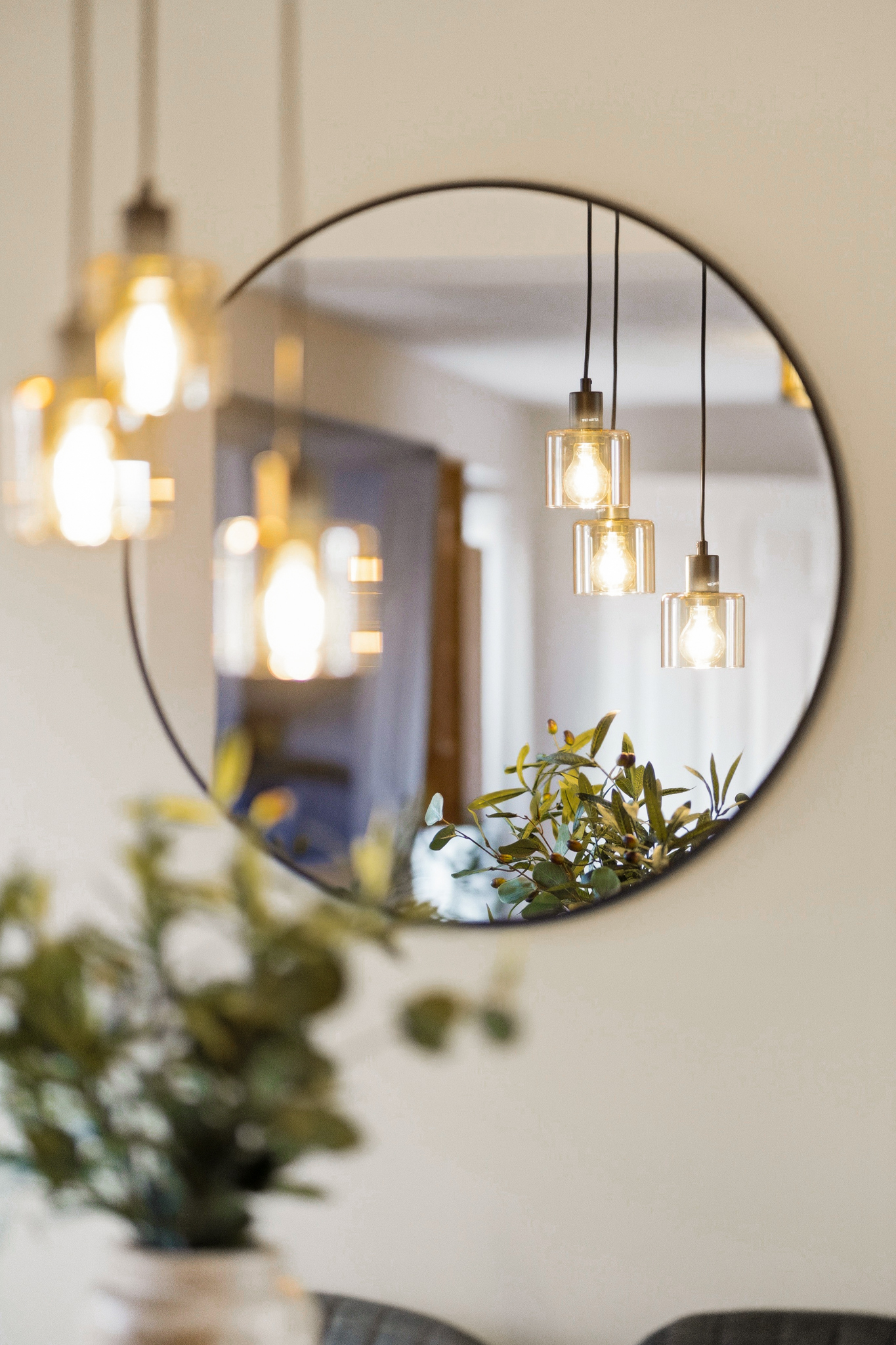 Modern mirror and warm pendant lighting for a chic, inviting ambiance